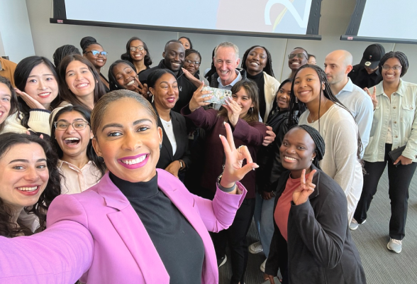 Woman taking a selfie in front of a large group of interns and Chairman and Chief Executive Officer 