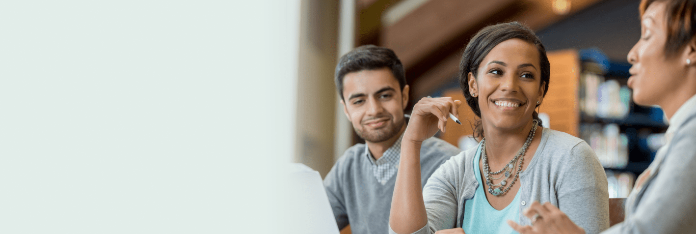 Three people sitting together, working. 