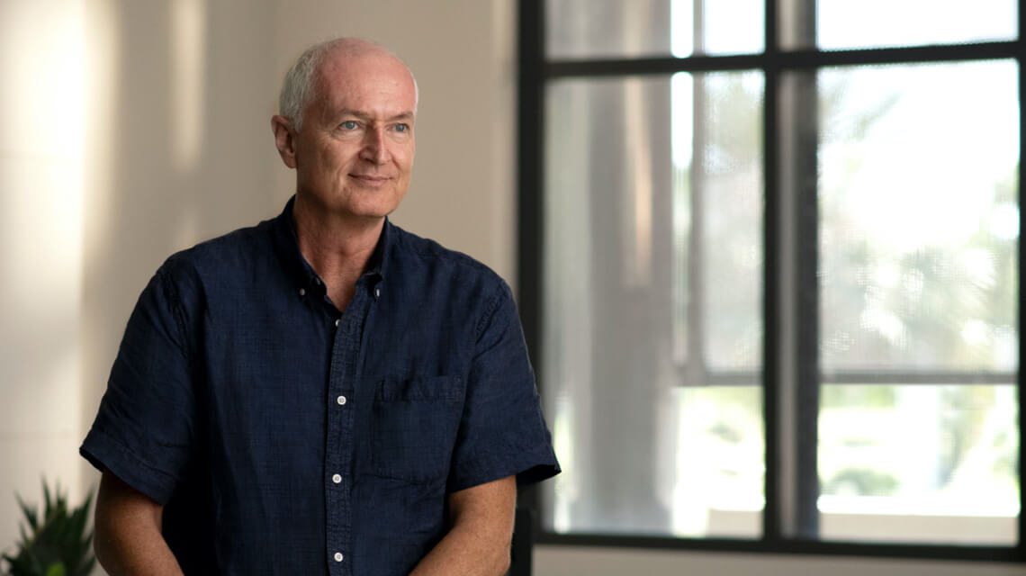 A man seating with a window in the background