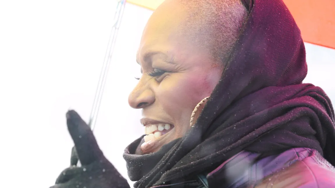 A closeup of woman wearing a headscarf with a joyous expression