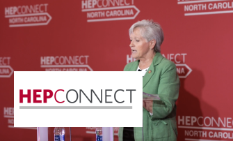 A woman speaking behind a podium with a HepConnect logo backdrop.