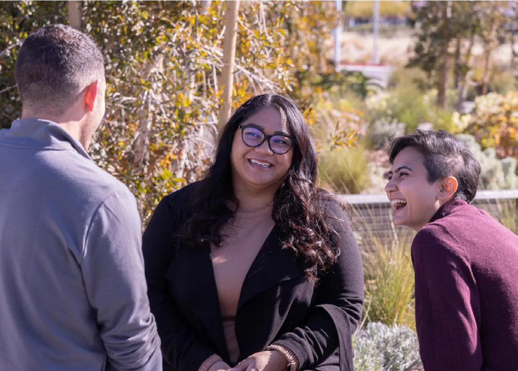 Three people gathered outside, laughing