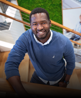 A man standing on a stair smiling.