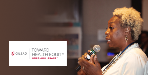 A woman in a white jacket speaking into a microphone.