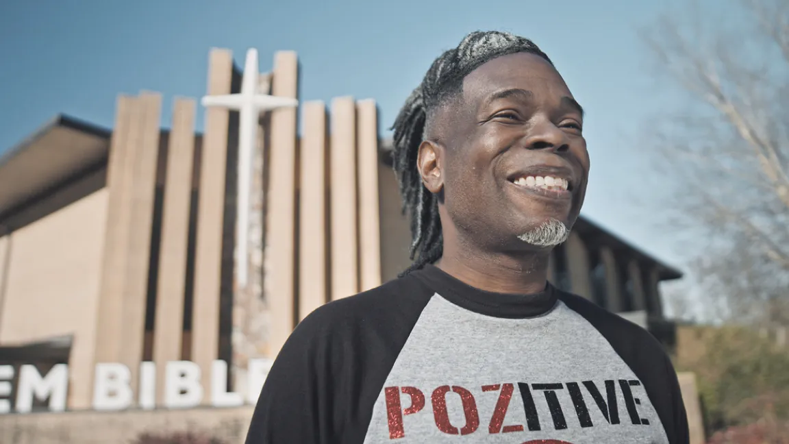 A man smiling outside of a church