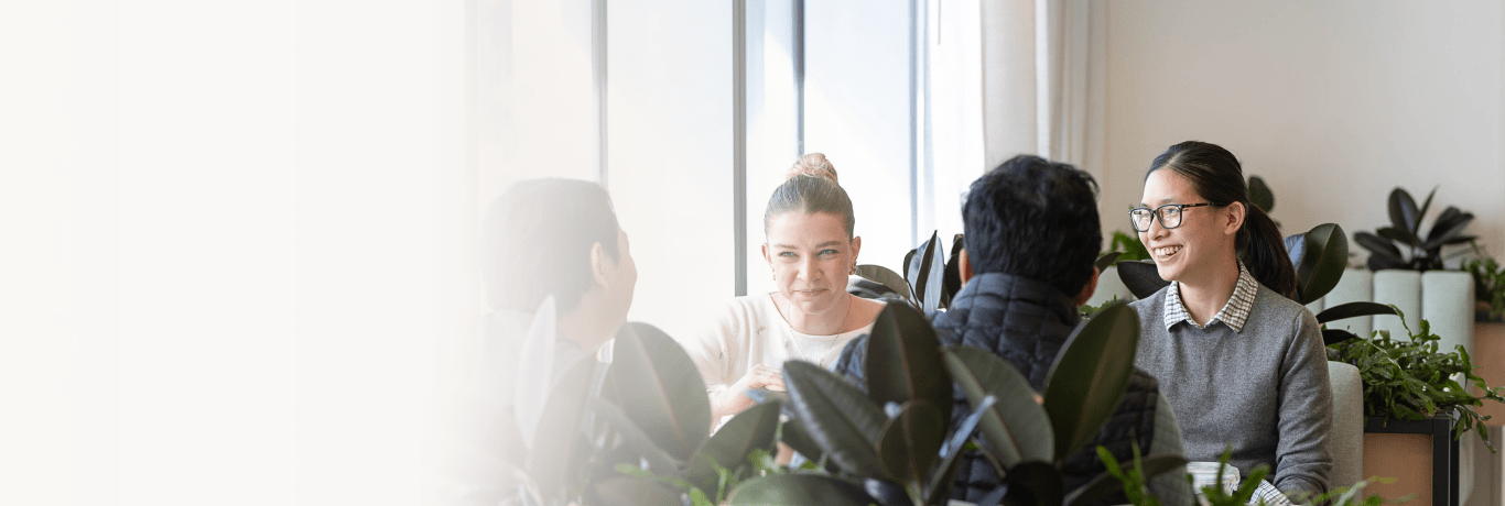 Four people sitting at the table and smiling