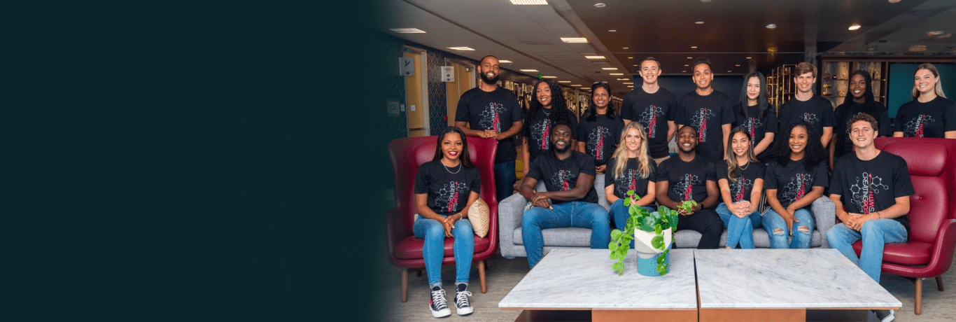 A group of about 18 interns wearing matching t-shirts